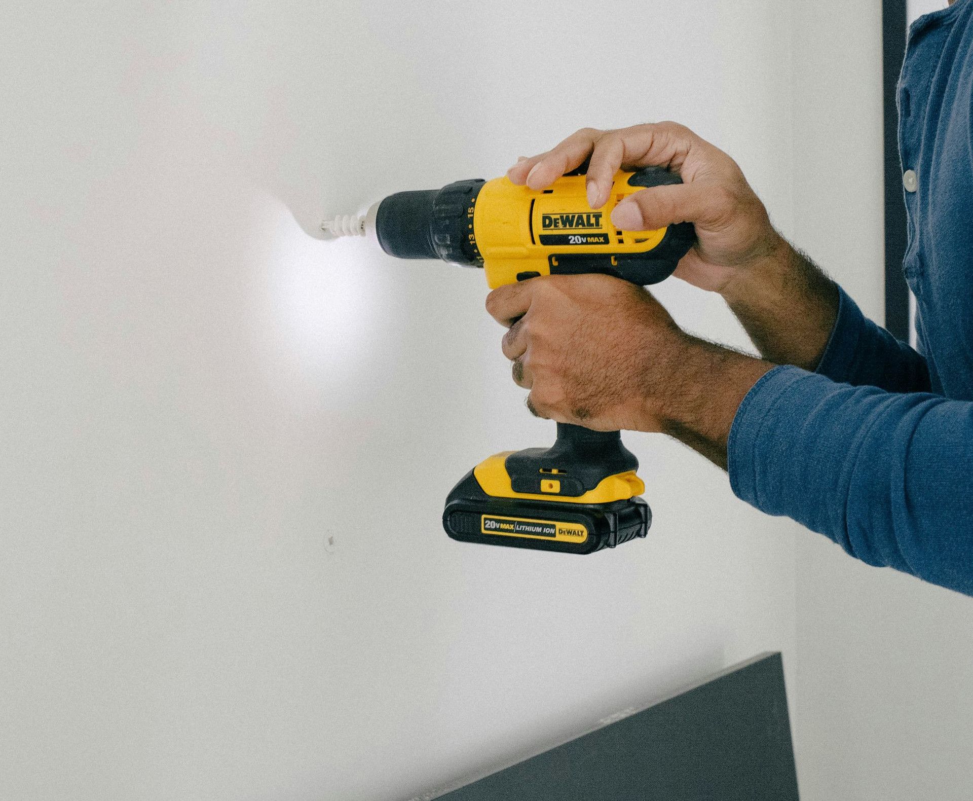 person holding yellow and black cordless hand drill